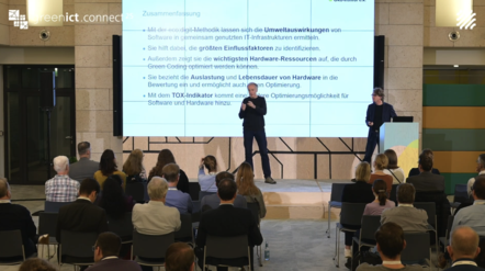Screenshot aus dem Youtube Video. Zu sehen sind Dirk Bunke und Jens Gröger, die auf der Bühne vor einem Fachpublikum das Fazit ihres Vortrags vorstellen. 